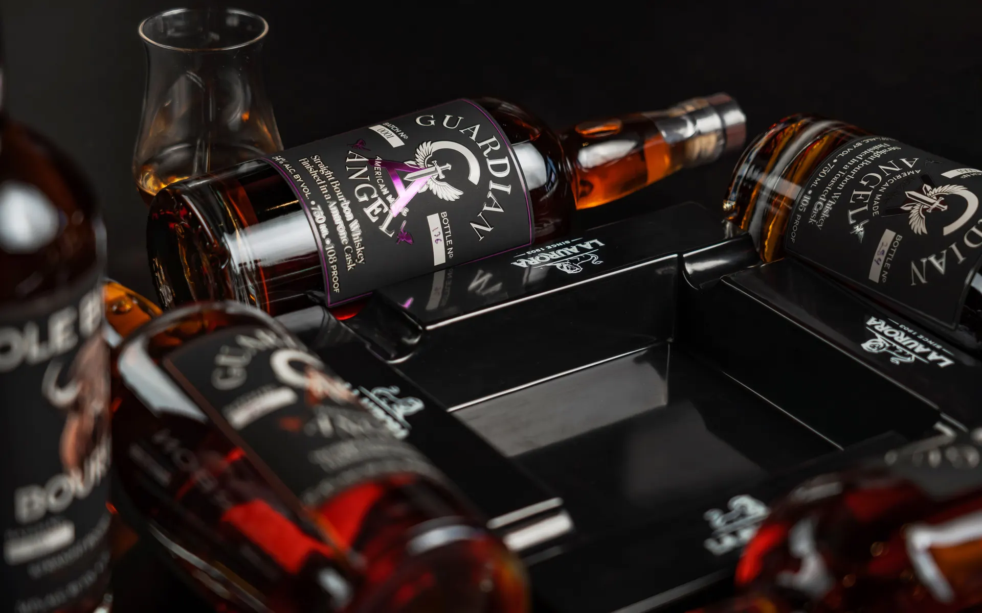 Single barrel bourbon whiskey bottles resting in a black presentation case
